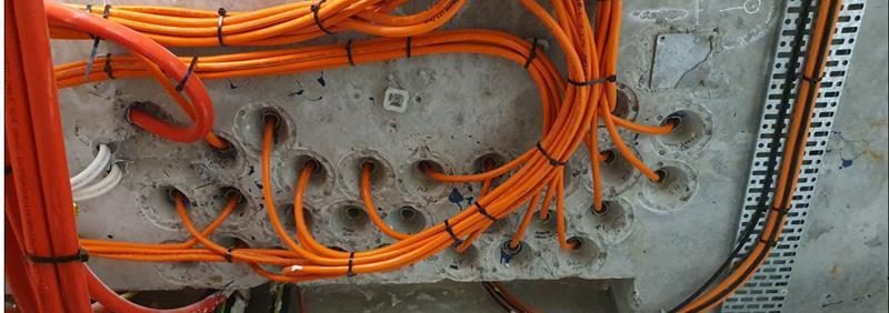 Orange cast in conduits in concrete sealed with FyrePEX HP intumescent sealant